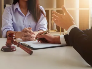 A pedestrian accident lawyer sitting with a client, discussing the details of their case in an office setting.